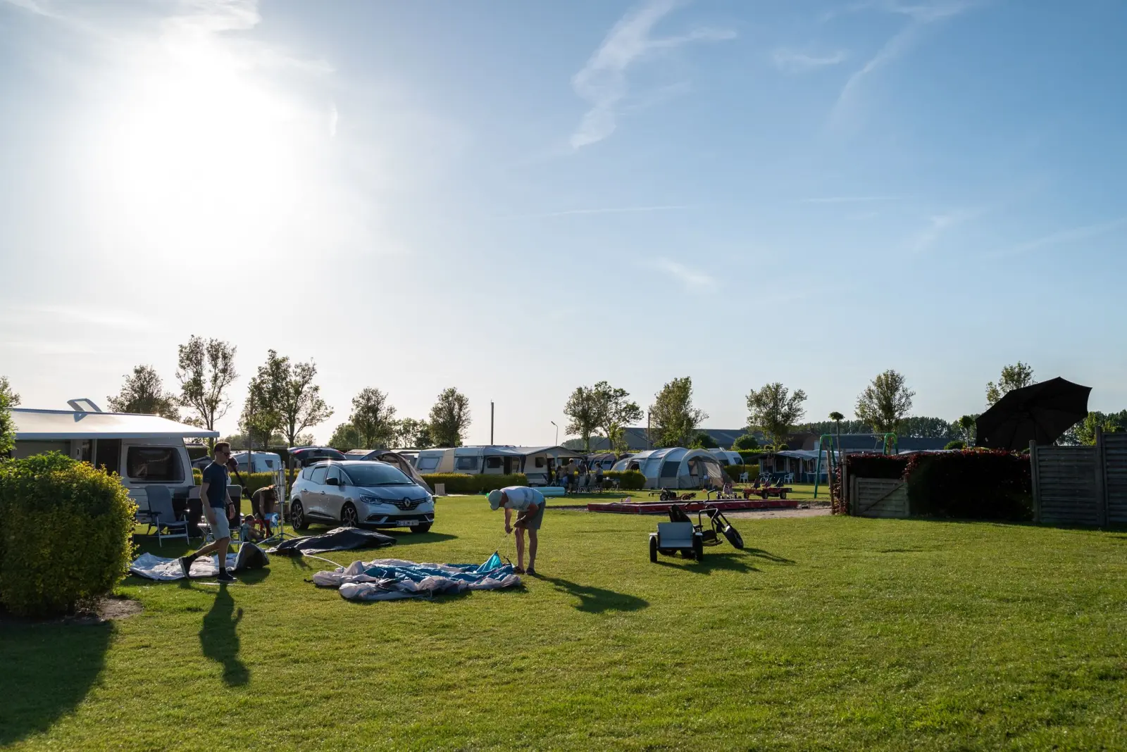 Tent opzetten op het ruime kampeerveld in de ochtendzon — Het Platte Putje