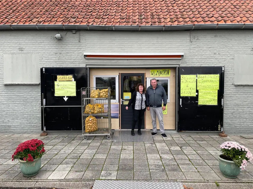 De ingang van verswinkel en cafetaria De Groe'ne Poort aan de Voorstraat 47 in Groede, met de uitbaters in de deuropening