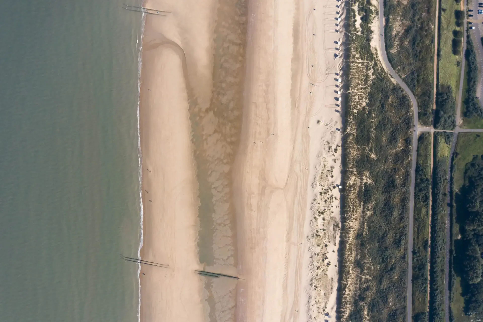 Luchtfoto van de kust bij Groede: zee, breed zandstrand en de polders van West Zeeuws-Vlaanderen